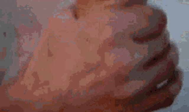 a close up of a person 's hand holding another person 's arm .