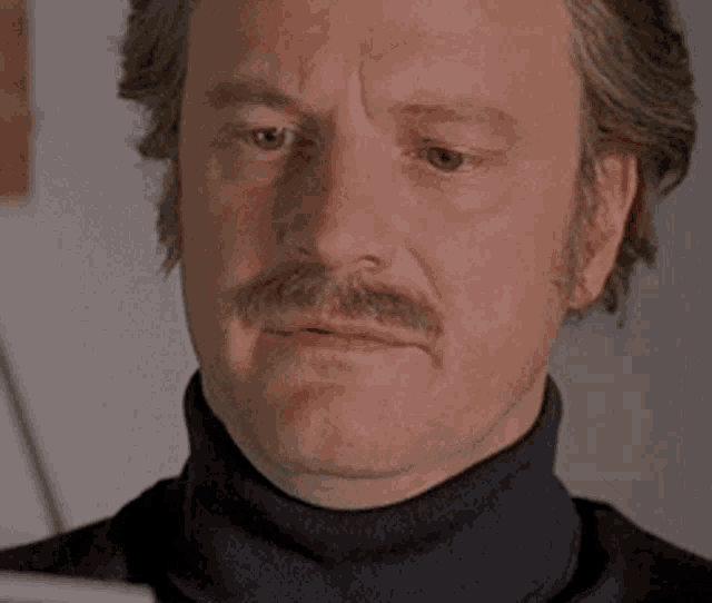 a man with a mustache wearing a black turtleneck sweater