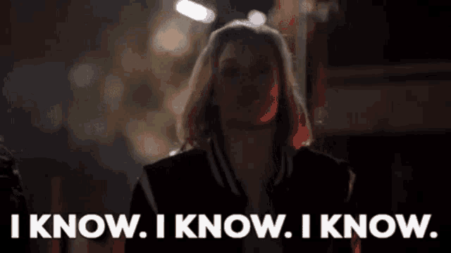a woman is standing in front of a sign that says `` i know . i know . i know '' .