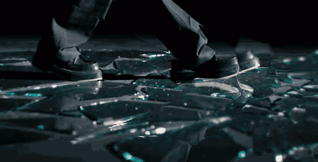 a person 's feet are on a broken glass floor