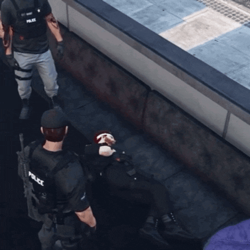 a police officer is standing next to a man laying on the ground