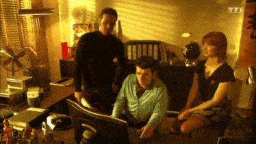 a group of people are looking at a computer screen with tfi written on the bottom