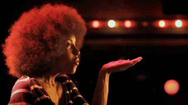 a woman with red hair blowing sparks out of her hands
