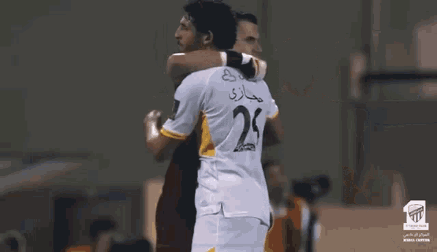 a soccer player with the number 16 on his jersey is hugging another player