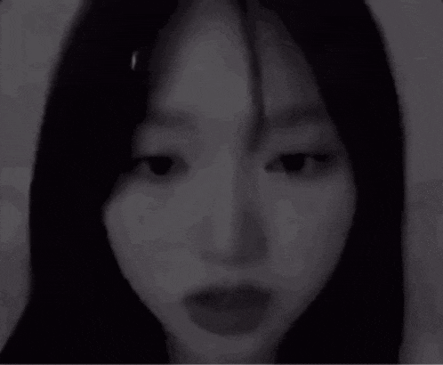 a black and white photo of a woman 's face with her mouth open .