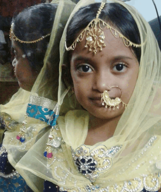 a little girl with a nose ring and a headpiece