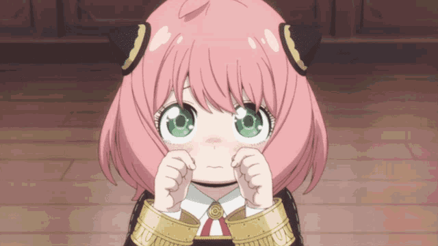 a girl with pink hair and green eyes is making a funny face