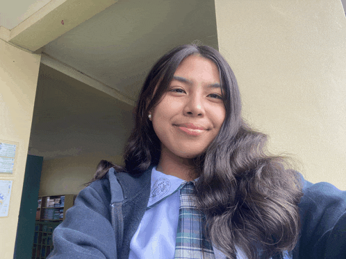 a girl in a school uniform is smiling for a picture