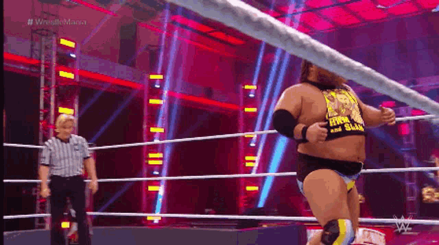 a man in a wrestling ring wearing a shirt that says ' king of the slums ' on it