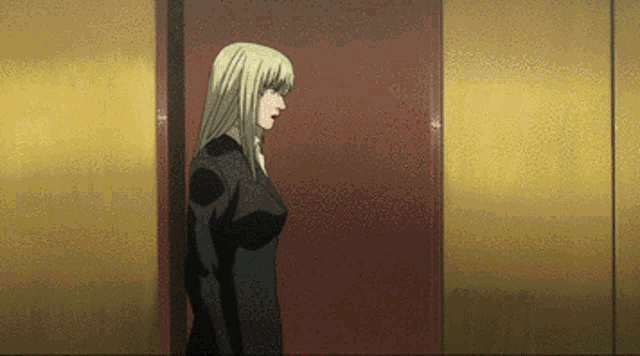 a woman in a black suit is standing in front of a door