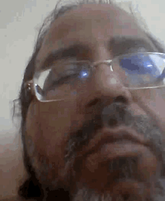 a man with glasses and a beard is making a face