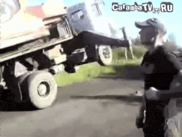 a man is standing in front of a truck that is on the side of the road and says carambatv.ru on the bottom