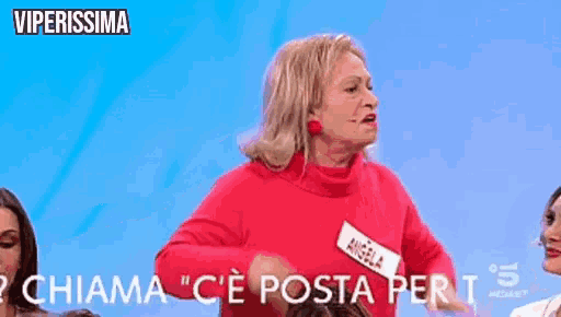 a woman in a red sweater with a name tag that says angela