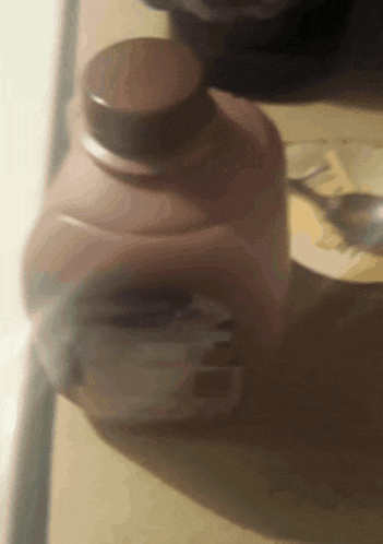 a close up of a bottle of milk with a spoon in it