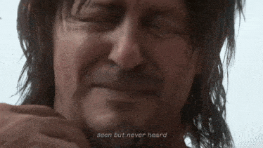 a close up of a man 's face with the words seen but never heard above him