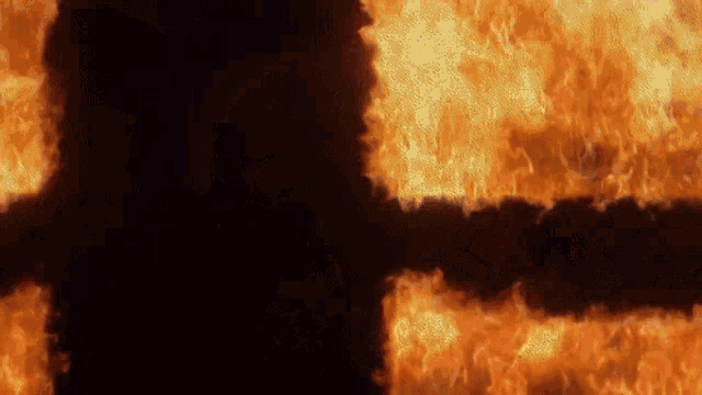 a silhouette of a man is surrounded by flames on a black background