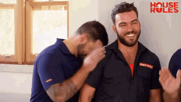 a group of men are laughing in front of a sign that says " house rules "