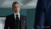 a man in a suit and tie standing next to another man in a suit .