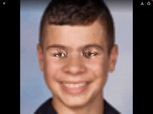 a close up of a young boy 's face with a blurry background .