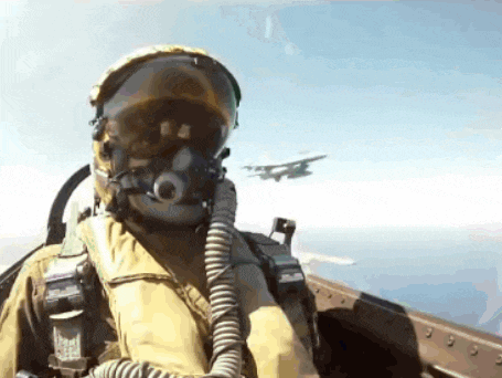 a fighter jet pilot wearing a helmet and goggles is flying in the air