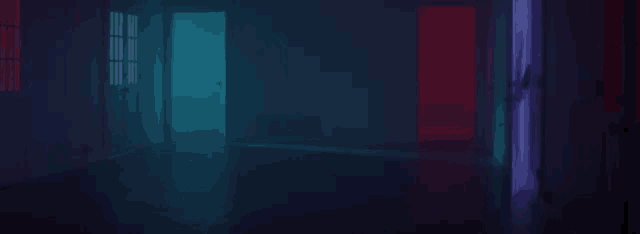 a woman stands in a dark room with blue and red lights on the doors