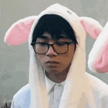 a young man wearing glasses and a bunny hat with ears .
