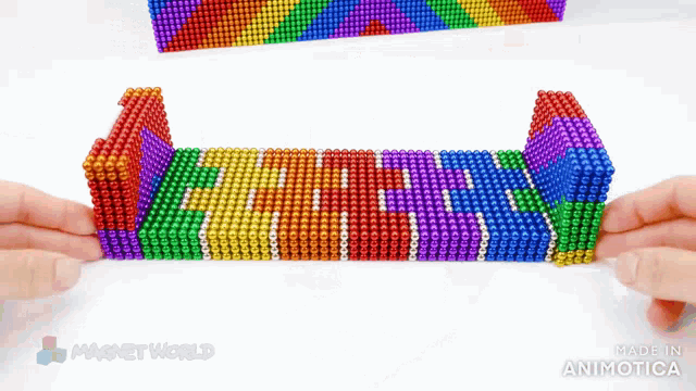 a person is playing with a rainbow colored toy made by magnet world