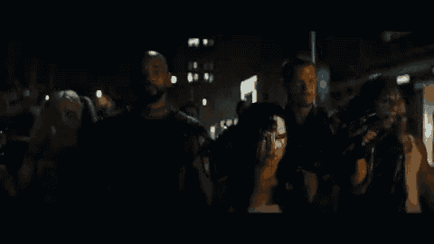 a group of people holding guns in a dark room .