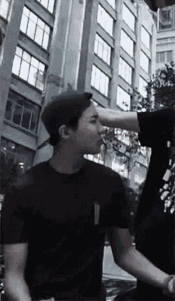 a man in a black t-shirt is standing next to another man in a black shirt .