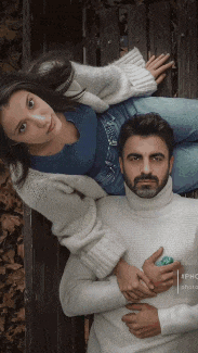 a man and woman laying on a wooden bench