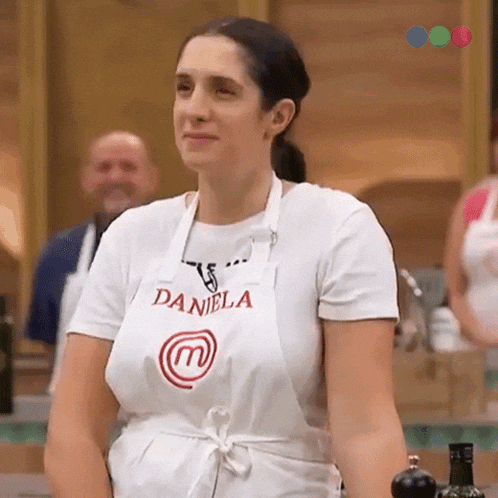 a woman wearing a white apron that says daniela on it