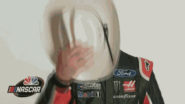 a man wearing a helmet and a nascar jacket