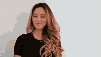 the woman is wearing a black shirt and has long hair .