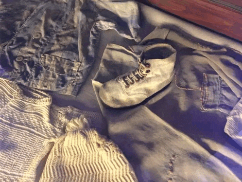 a pair of baby shoes laying on a blanket