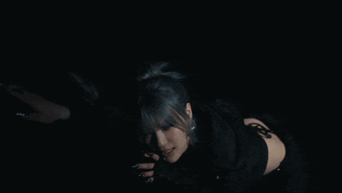 a woman with long nails is laying on the floor