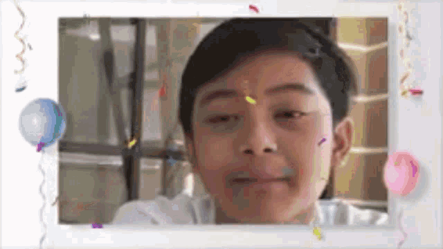 a young boy is making a funny face in a picture frame surrounded by confetti and balloons .