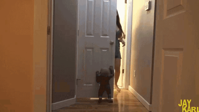 a woman walking down a hallway with the name jay karl on the bottom