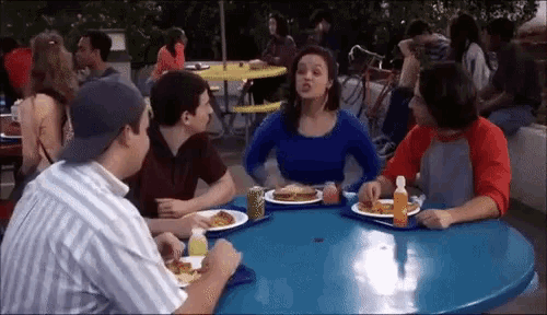 a group of people sitting around a table eating food