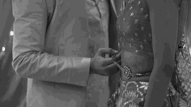 a man and woman are looking at each other in a black and white photo