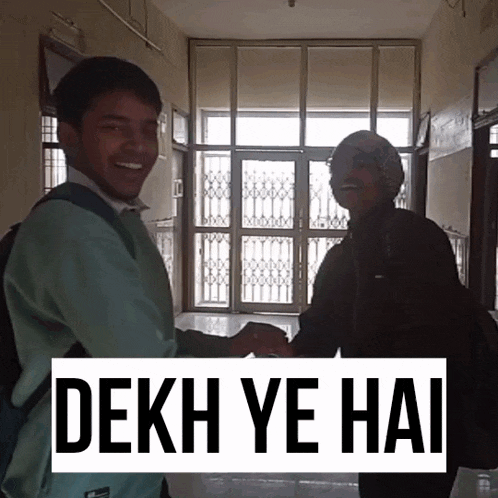 two people shaking hands in a hallway with a sign that says " dekh ye hai " on it