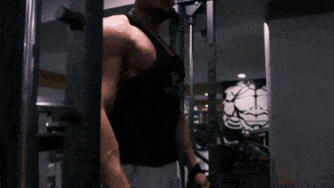 a man wearing sunglasses and a black tank top is working out on a machine in a gym