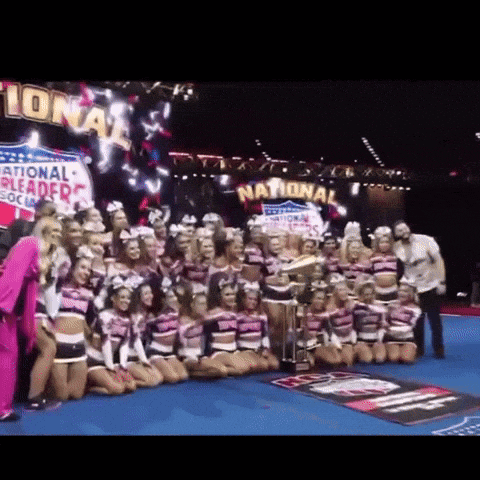 a group of cheerleaders are posing for a picture in front of a sign that says national on it