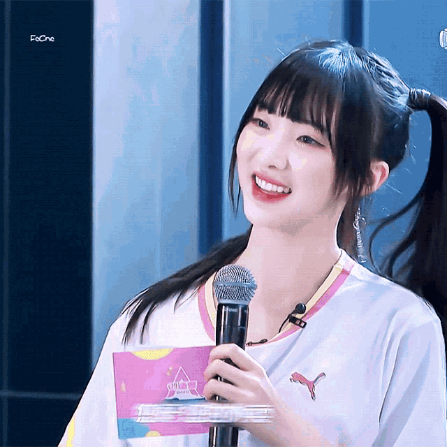 a girl holding a microphone with a puma logo on the front