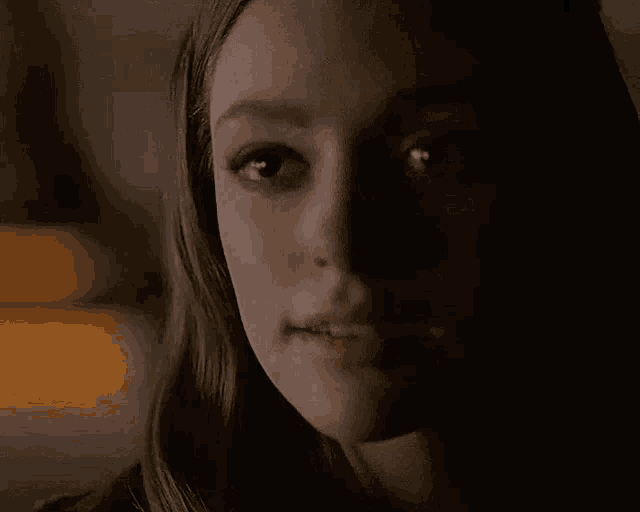 a close up of a woman 's face in the dark