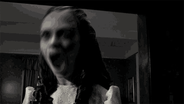a blurry picture of a woman in a white dress standing in a dark room