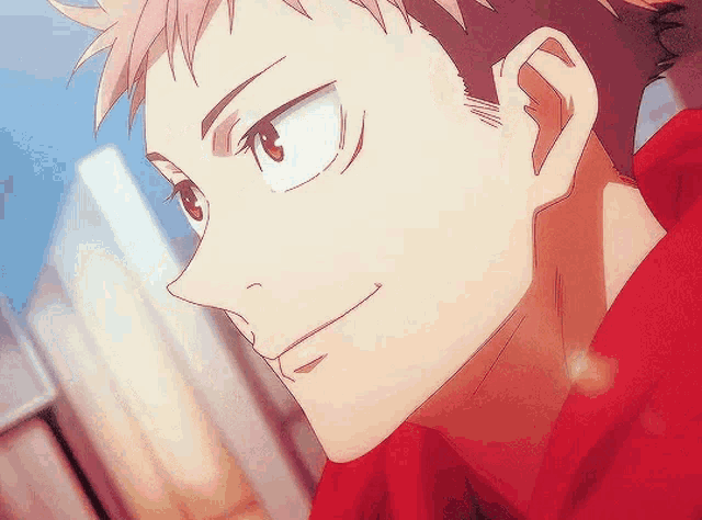 a close up of a person 's face with a red shirt on and a smile on their face .