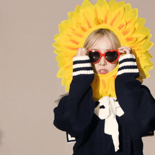 a girl wearing a sunflower hat and sunglasses