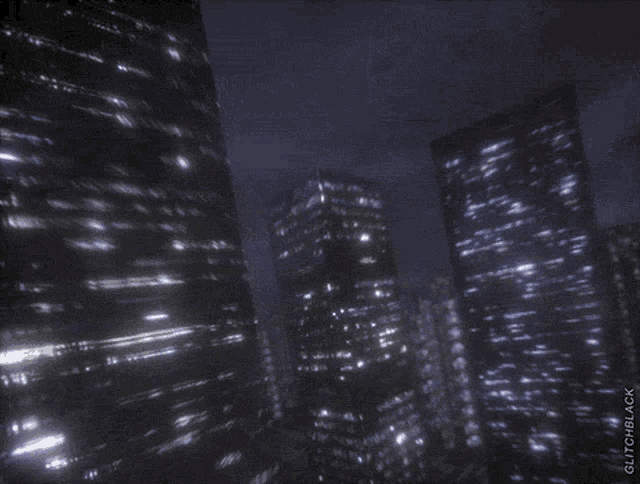 a blurry picture of a city at night with the words " glitchblack " below it