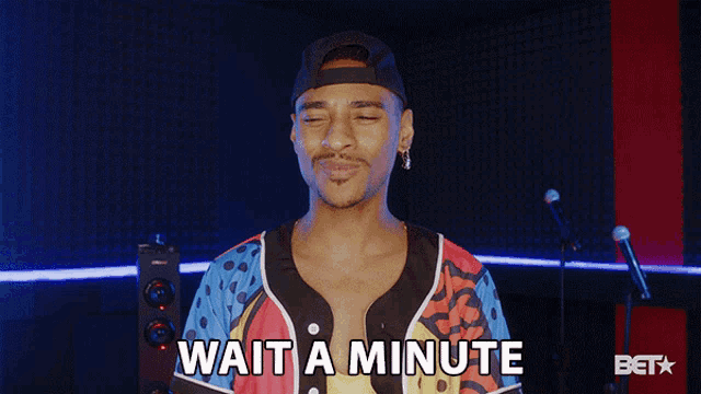 a man says wait a minute in front of a bet logo