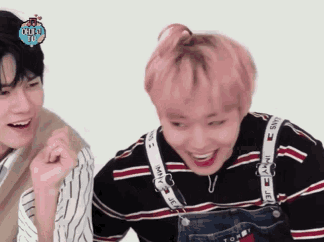 a boy with pink hair wearing overalls and a tommy hilfiger shirt